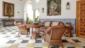 A spacious lobby with checkered flooring, wicker furniture, and decorative tiles. - San José 3 by Home at Homes (Sevilla)
