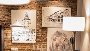 A cozy living room with a brick wall, a sofa, a side table, and artwork. - Quiboo (Brasov)