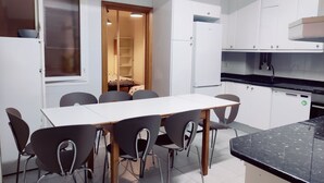 Une cuisine de taille réduite comprenant une table et des chaises, un réfrigérateur et des placards.