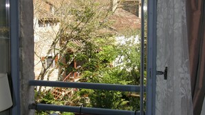 Una ventana con vistas a un pueblo histórico, incluyendo una torre destacada.