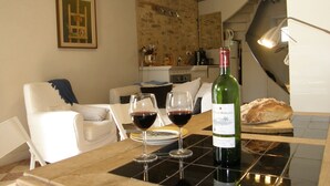 Comedor con una mesa dispuesta para dos personas, una botella de vino y dos copas.