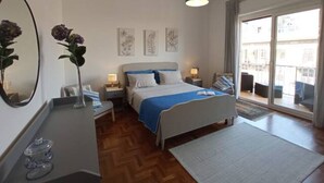 A bedroom with a bed, bedside tables, a mirror, and artwork on the wall.