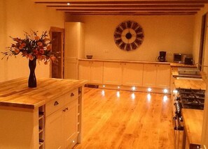 Una cocina con armarios de madera, una isla central y un reloj de pared.