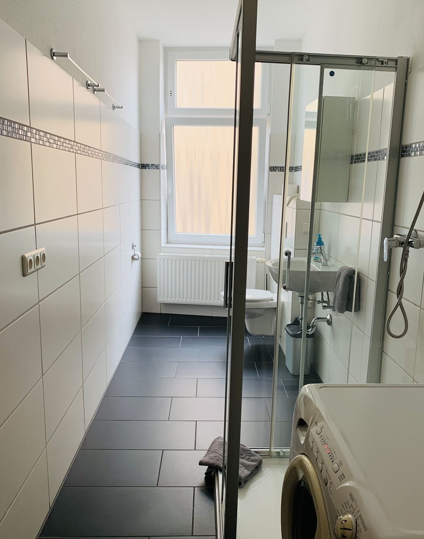 Ein modernes Badezimmer mit Duschkabine aus Glas, Toilette und Waschbecken.