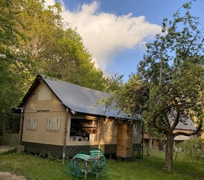 A small, single-story building with a sloped roof, surrounded by trees and grass. - Ecolodge Beauregard (Treigny-Perreuse-Sainte-Colombe)