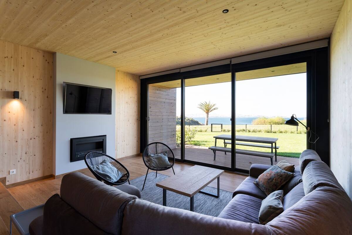 A modern living room with a large sliding glass door leading to an outdoor patio.