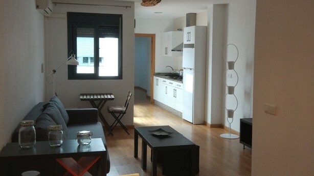 Un appartement moderne comprenant un coin repas, une cuisine et un espace de vie.