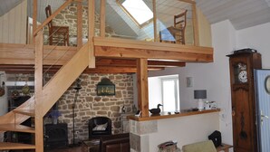 A loft-style room with a wooden staircase, stone walls, a fireplace, and a large skylight. - House / Villa - Plogoff (Plogoff)