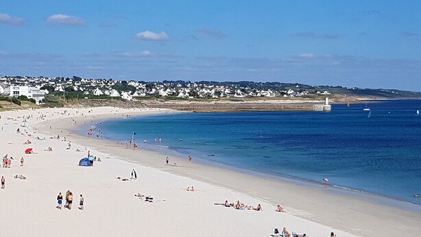 A wide sandy beach with clear blue water, a lighthouse in the distance, and a row of white houses along the shore. - House / Villa - Plogoff (Plogoff)