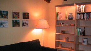 A living room with a sofa, a lamp, and a bookshelf with various items. - mansion - Riccò del Golfo (Riccò del Golfo)