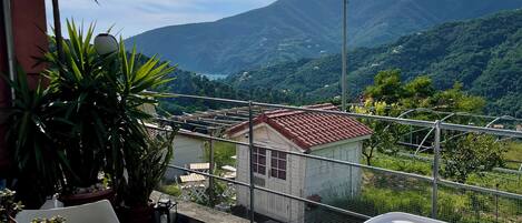 Un balcón con mesa y sillas, con vistas a un paisaje montañoso.