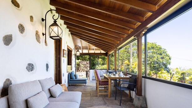 A covered patio area with a sofa, dining table, and chairs. - El Nogal House, La Orotava (La Orotava)