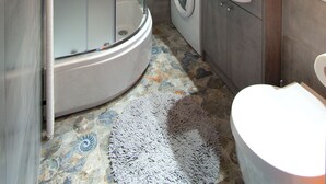 A modern bathroom with a glass-enclosed shower, a washing machine, and a sink. - Locum Magdalena Wroclaw Market (Wroclaw)