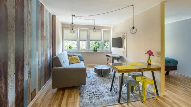 A modern living room with a sofa, coffee table, and dining area. - Locum Magdalena Wroclaw Market (Wroclaw)
