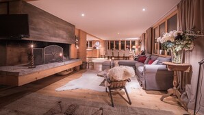A cozy living room with a fireplace, seating area, and a television. - Cozy free standing Chalet with garden and amazing mountain views (Grindelwald)