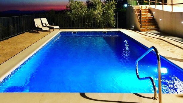 A swimming pool with a view of the sky and trees.