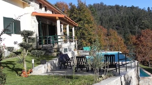 Una casa con patio, mobiliario exterior y piscina.