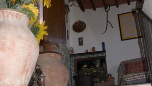 A staircase with a tiled border, a large vase with flowers, and a rustic ceiling. - Beautiful stone house with garden and private pool. (Sovicille - Siena)