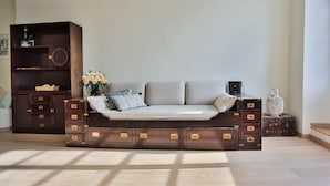 Ein modernes Wohnzimmer mit einer Couch, einem Holzschrank mit Schubladen und einem kleinen Tisch mit einer Laterne.