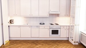 Uma cozinha moderna com armários brancos, lava-louças, forno e fogão.