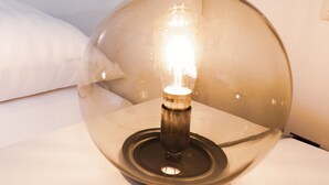 Uma lâmpada moderna com cúpula de vidro transparente e lâmpada visível no interior.
