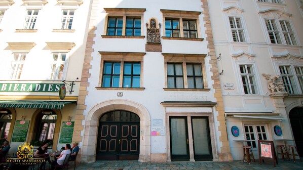 A historic building with a central entrance, large windows, and a sign for 'BIERADIES'.