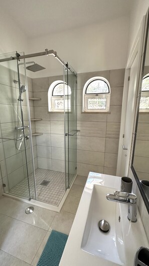 Kombination af bruser/badekar, hårtørrer, bidet, håndklæder