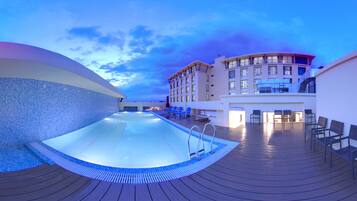 Alberca al aire libre, sombrillas en la alberca y camastros