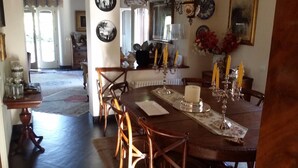 Un comedor con una mesa de madera, sillas y un candelabro con velas.