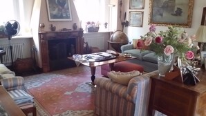 Una sala de estar acogedora con chimenea, un globo terráqueo y una mesa con diversos objetos.