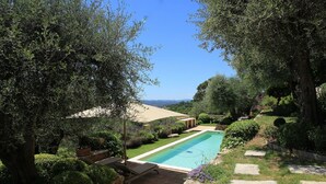 A swimming pool surrounded by lush greenery and stone pathways. - Villa La Lavande Has A Heated Pool And Magnificent Sea, Golf And Mountain Views (Châteauneuf-Grasse)