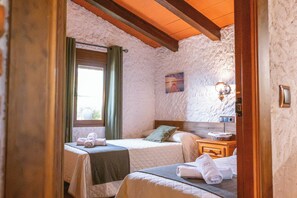A bedroom with two beds, a window with curtains, a nightstand with a lamp, and a painting on the wall. - The Golden Valley: A rural paradise in the Sierra de Cádiz. (El Gastor)