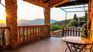 A stone balcony with a view of a mountainous landscape.