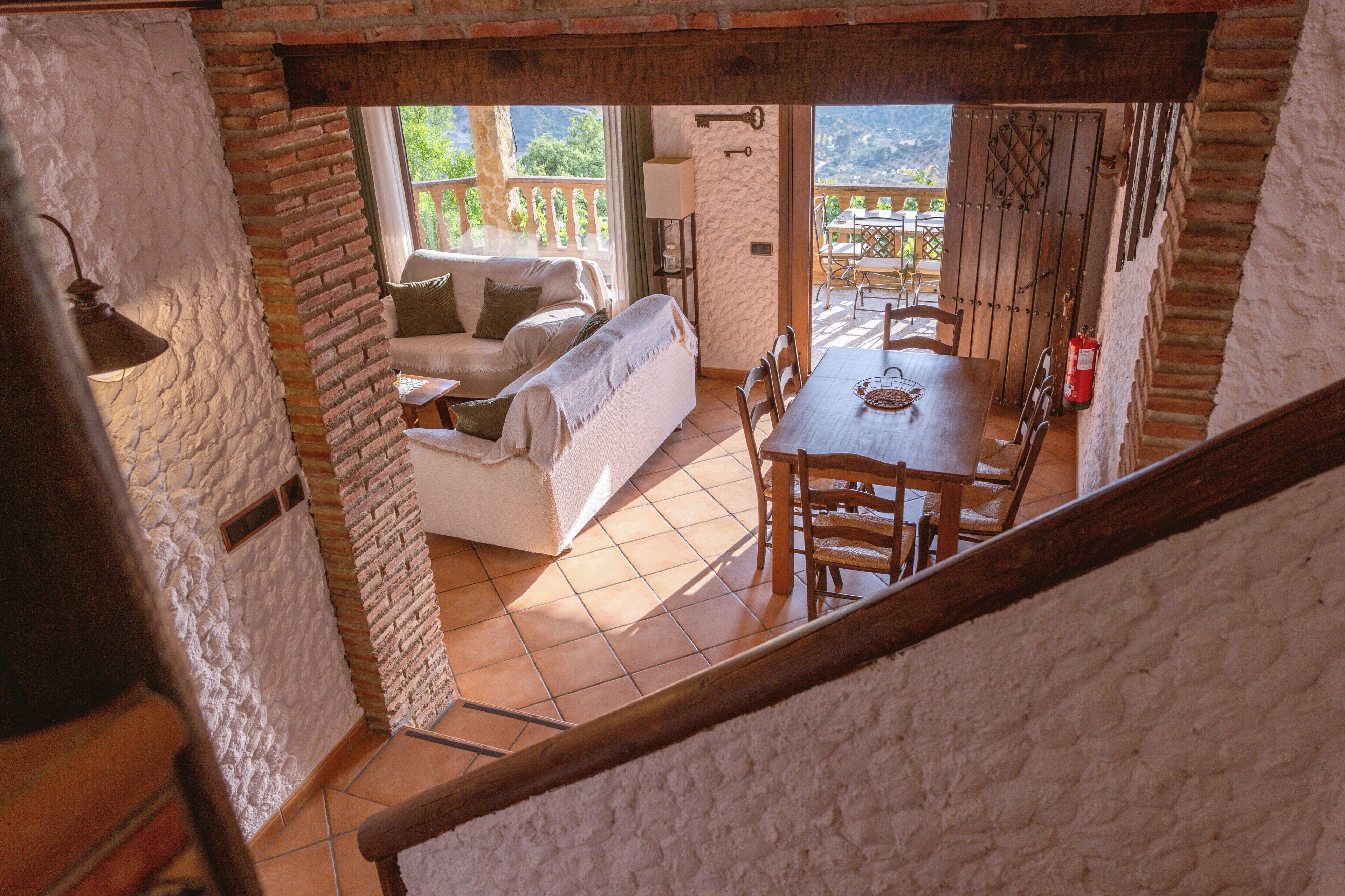Un espacio interior acogedor con comedor, sofá y escalera.