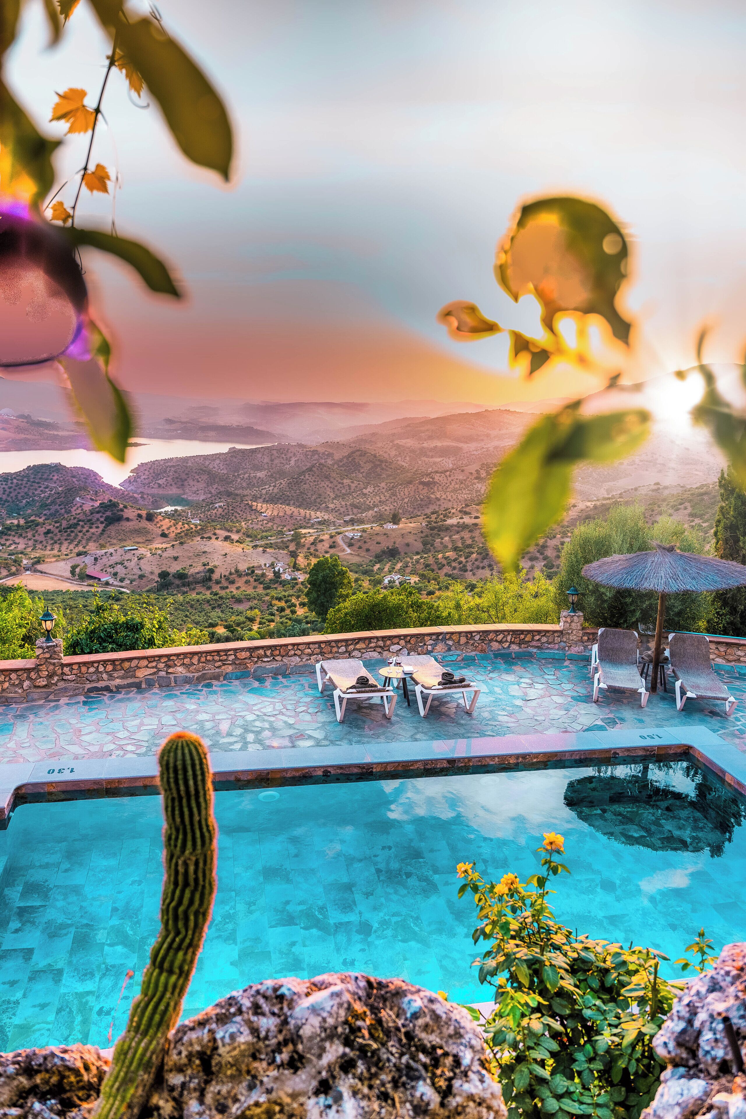 A swimming pool with lounge chairs and a view of a valley.