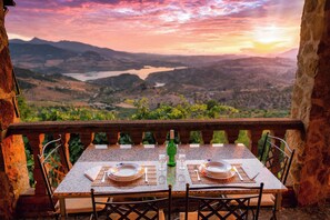 A table set for two with a view of a valley and lake. - The Golden Valley: A rural paradise in the Sierra de Cádiz. (El Gastor)
