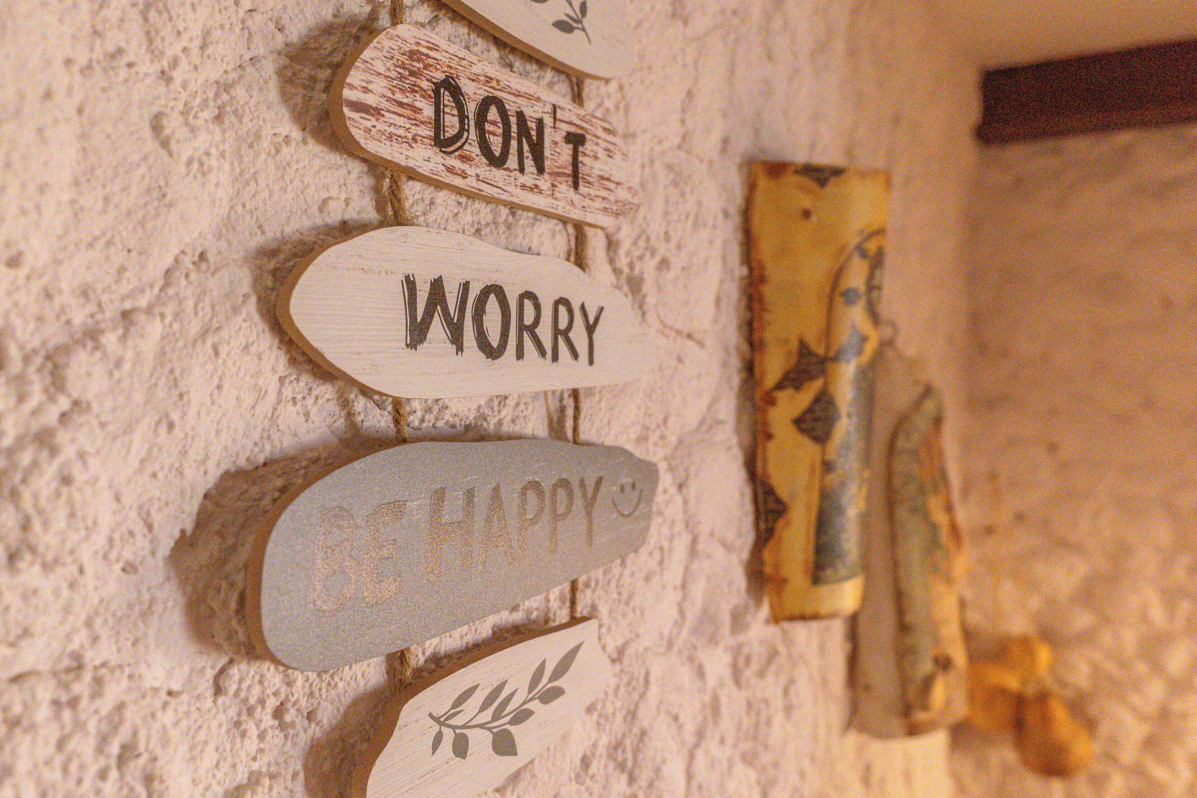A wall with signs saying 'DON'T WORRY' and 'HAPPY'.