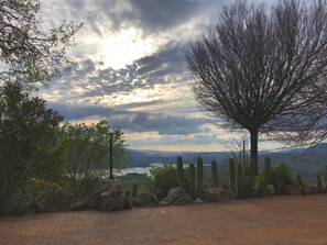 A desert landscape with cacti, a tree, and a view of distant mountains under a cloudy sky. - The Golden Valley: A rural paradise in the Sierra de Cádiz. (El Gastor)