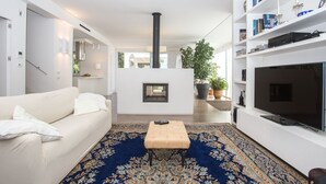 A modern living room with a sofa, ottoman, and a large flat-screen TV. - Modern detached villa near the beach of Mondello (Palermo)