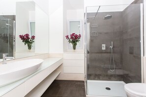 Een bad/douchecombinatie, een haardroger, een bidet, handdoeken
