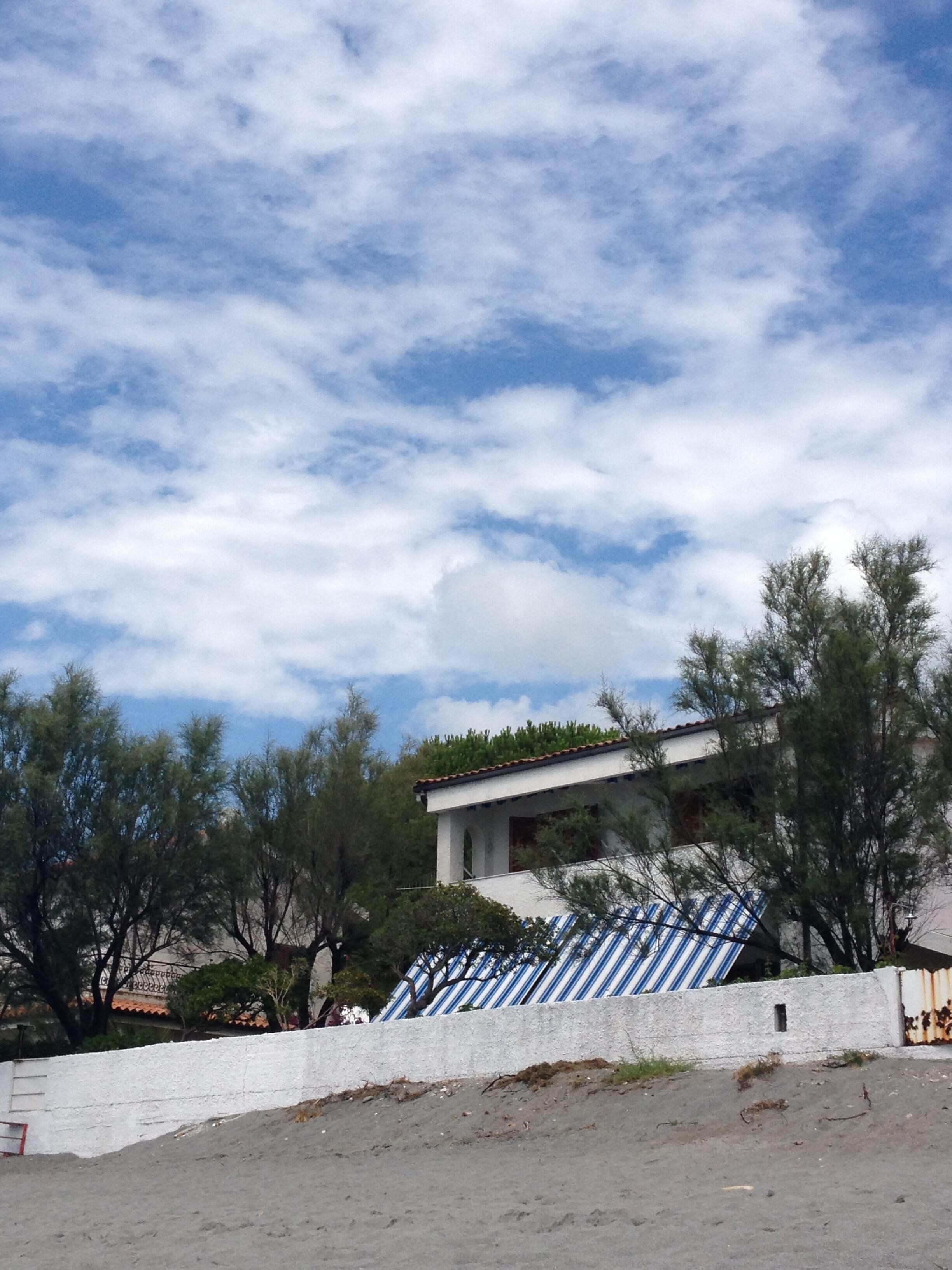 A building with a white facade and a blue and white striped awning.