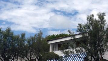 A building with a white facade and a blue and white striped awning.
