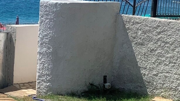 A concrete structure with a metal railing overlooking a body of water.