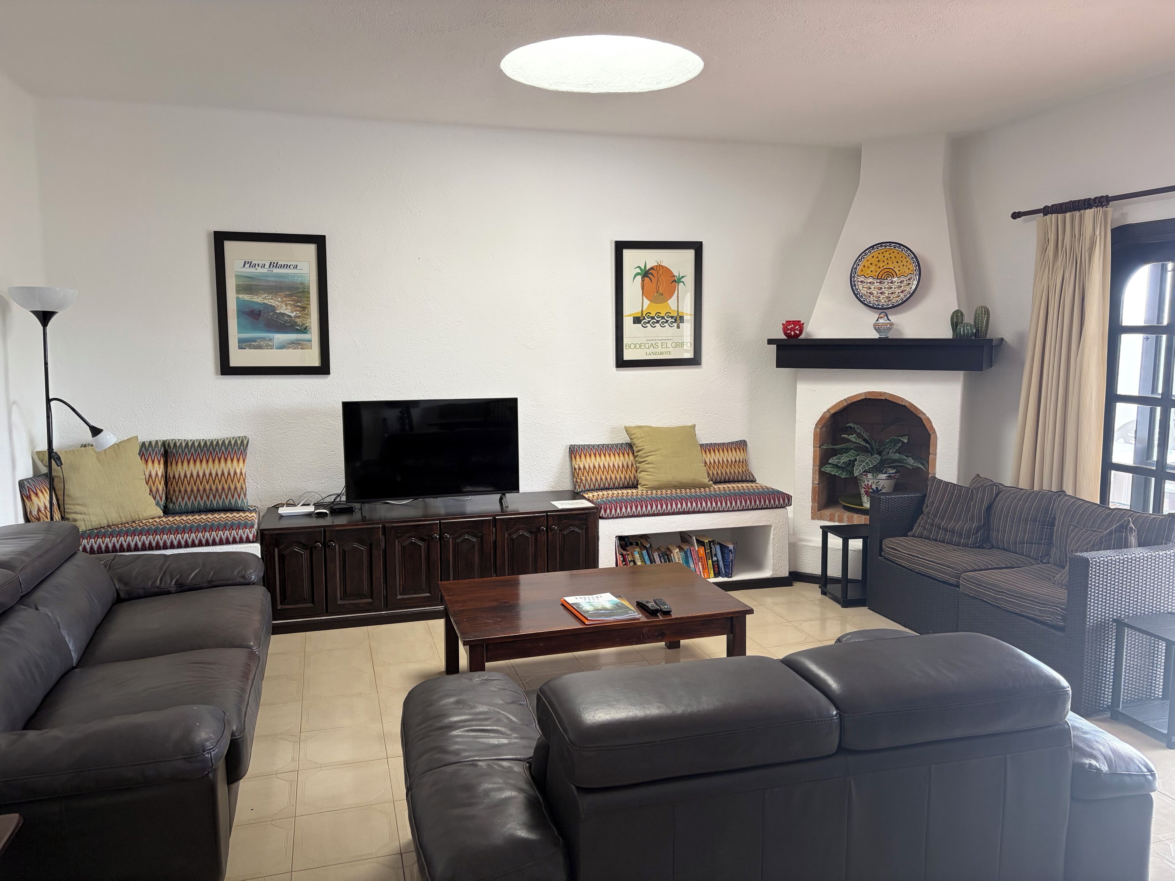 A living room with a sofa, a coffee table, a TV, and a fireplace.
