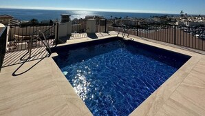 Piscina en la azotea con vistas despejadas al océano y al paisaje urbano.