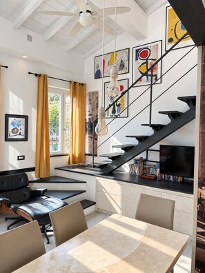 Ein modernes Interieur mit einer Treppe, einem Essbereich und Kunstwerken an den Wänden.