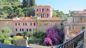 A multi-story building with balconies, surrounded by lush greenery and flowering plants. - Architectural designed  central apartment a few steps from the beaches. PARKING. (sestri levante)