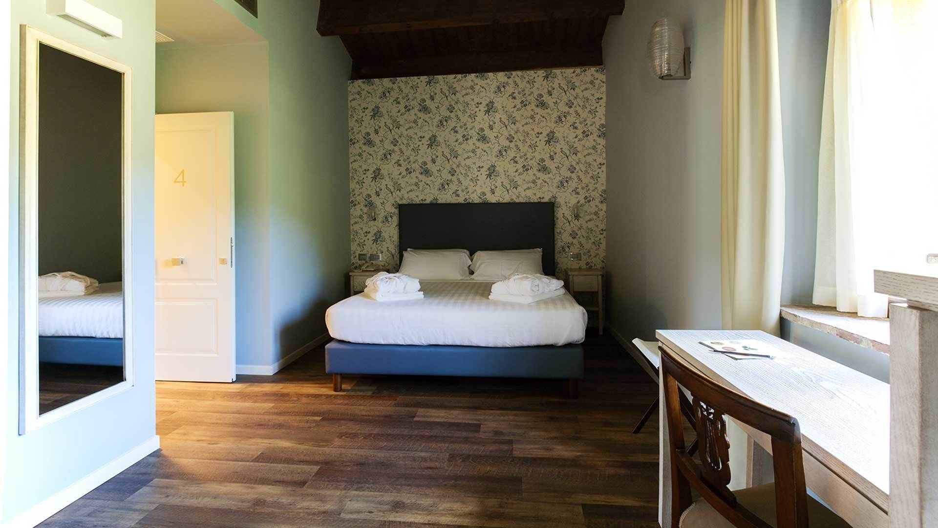 A bedroom with a bed, a desk, and a door.