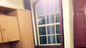 Una mesa de madera con sillas, un aparador de madera y una ventana con vistas.