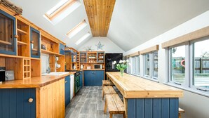 A kitchen with wooden cabinets, a wooden countertop, and a bench. - Beautiful cabin near Bath with heated swimming pool sleeps up to 17 people (Bristol)